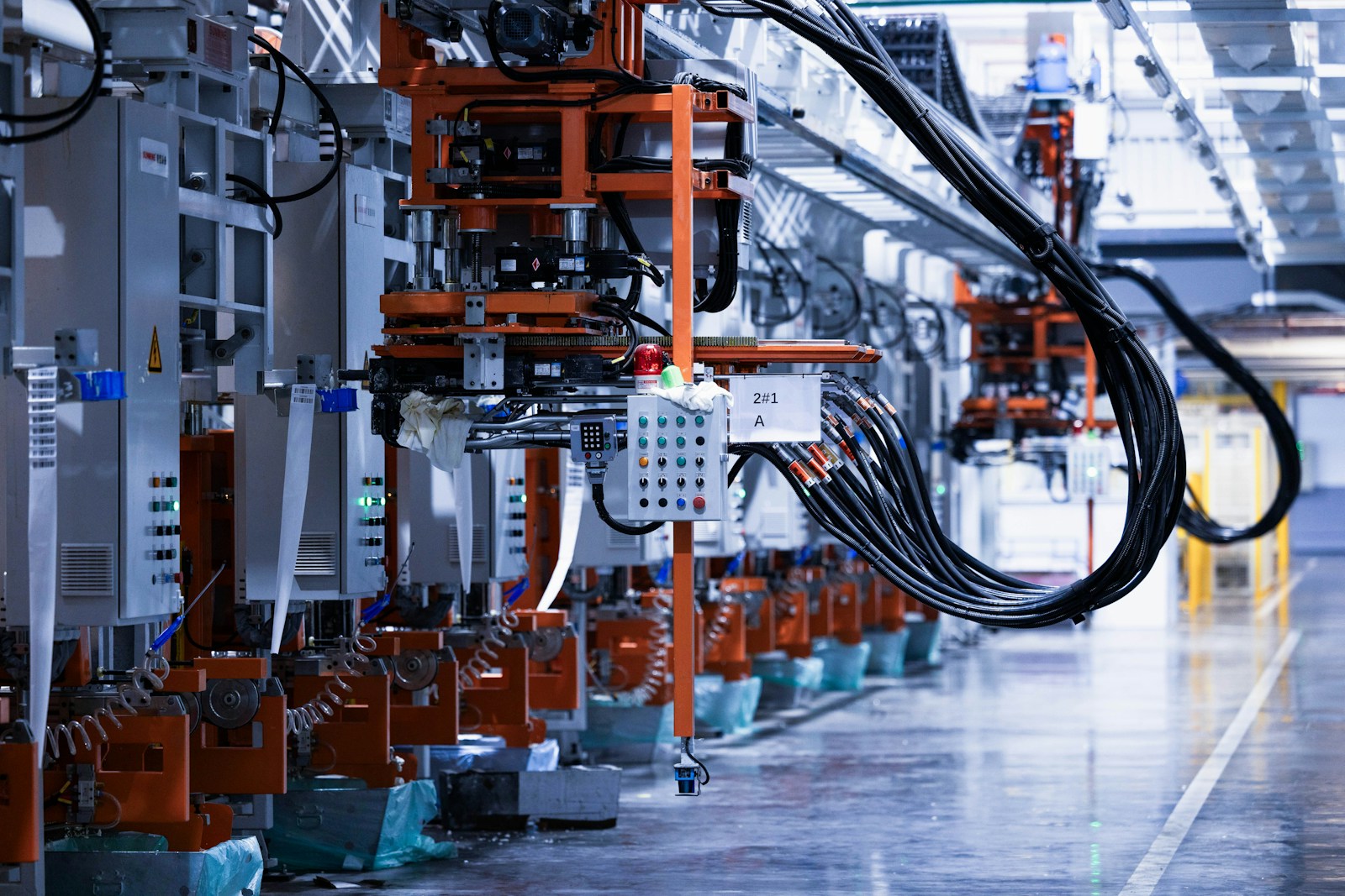 Industrial factory floor with orange machinery and cables