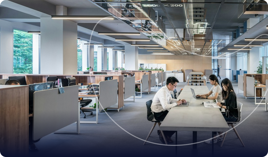 Modern open-plan office with people collaborating at a table